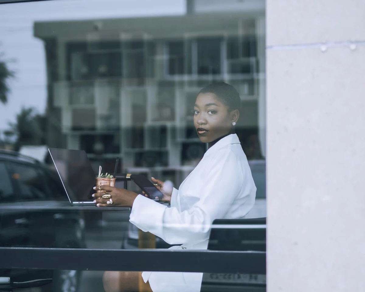 A businesswoman working on her laptop and phone in a café